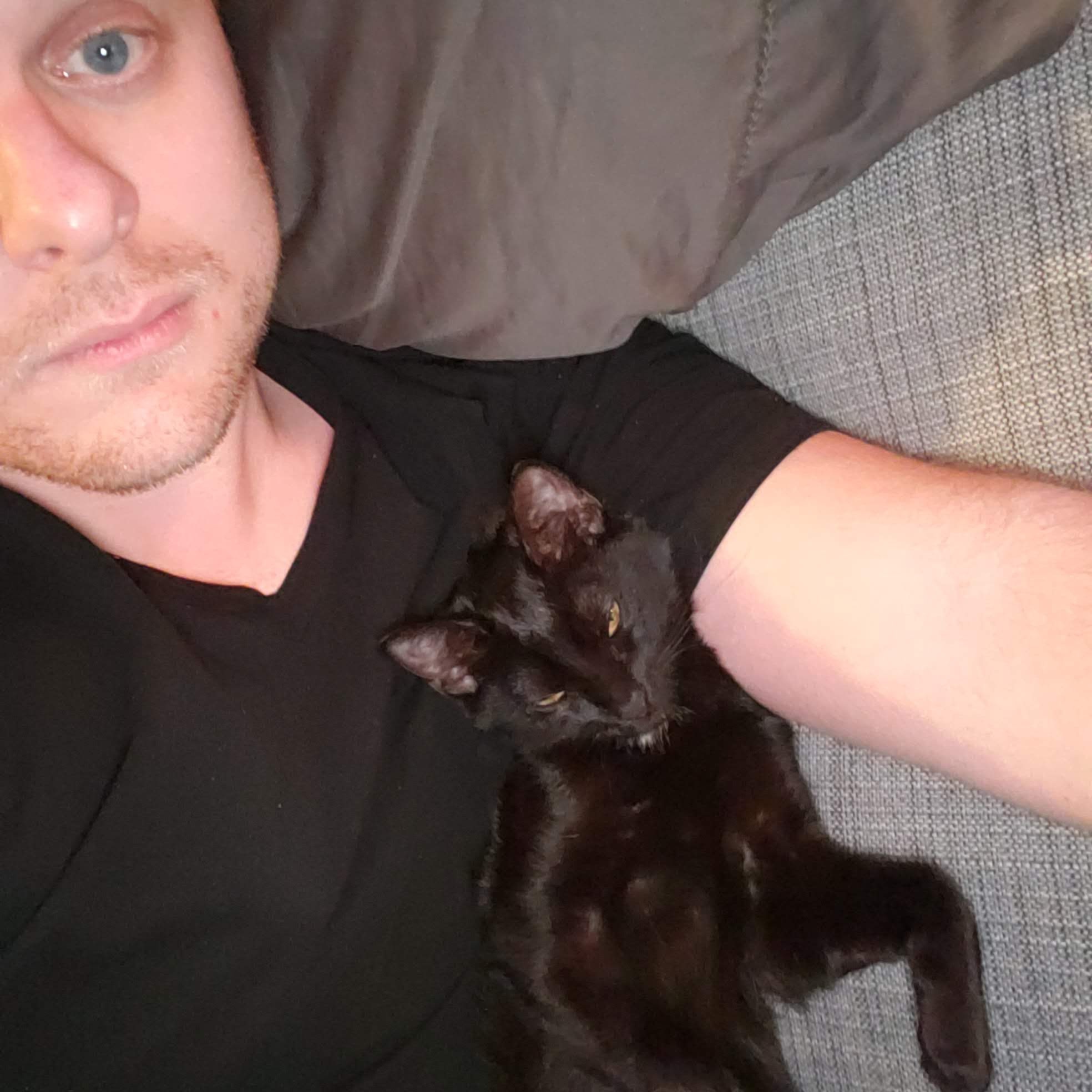 The author and his black cat Bit on a couch.